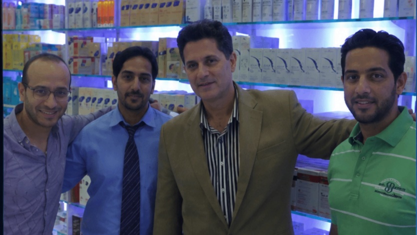 Continuum Innovative team with pharmacy retail partners in front of an in-store HairGenesis retail display in the GCC.